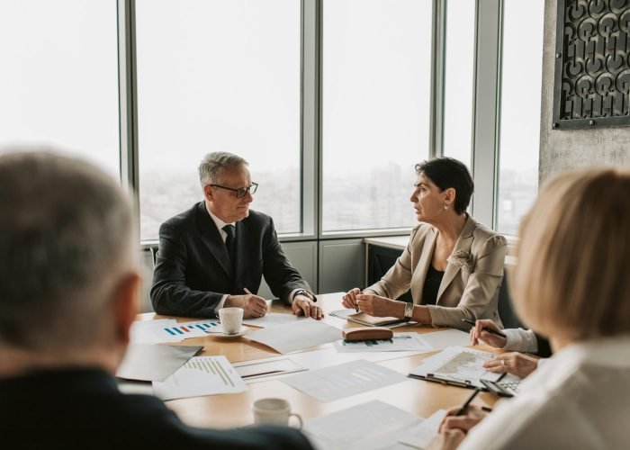 Business professionals engaged in a strategic meeting in a modern office setting with natural light.