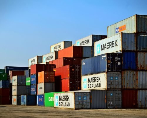 Colorful stacked shipping containers at a port exemplify global logistics.